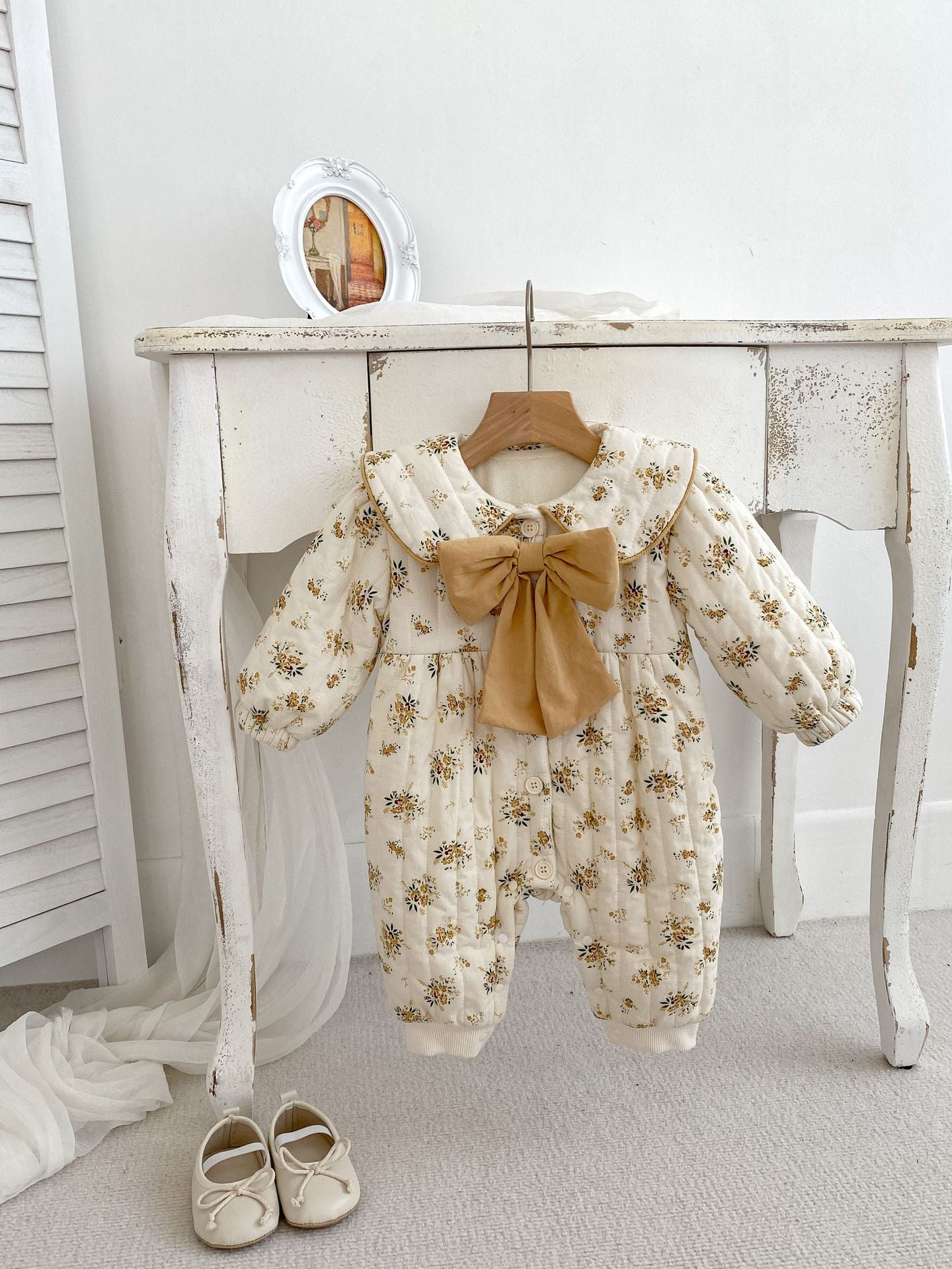 Baby toddler girl wearing a beige fleece floral print outfit with a big bow-knot and long sleeves, perfect for winter.