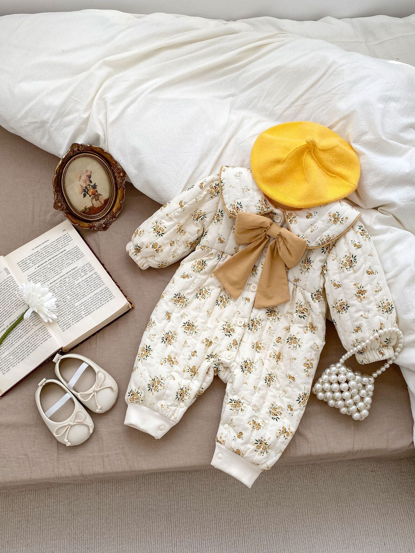 Baby toddler girl wearing a beige fleece floral print outfit with a big bow-knot and long sleeves, perfect for winter.