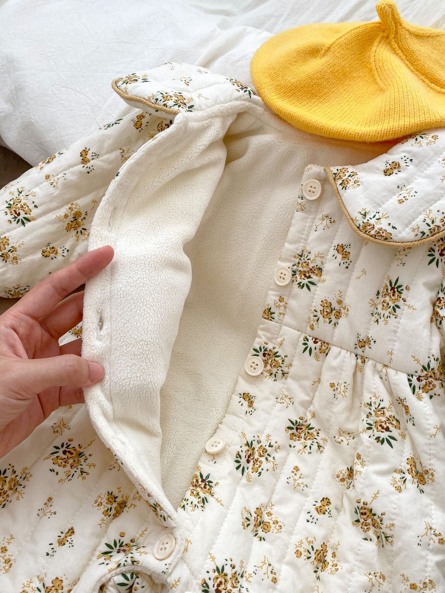 Baby toddler girl wearing a beige fleece floral print outfit with a big bow-knot and long sleeves, perfect for winter.