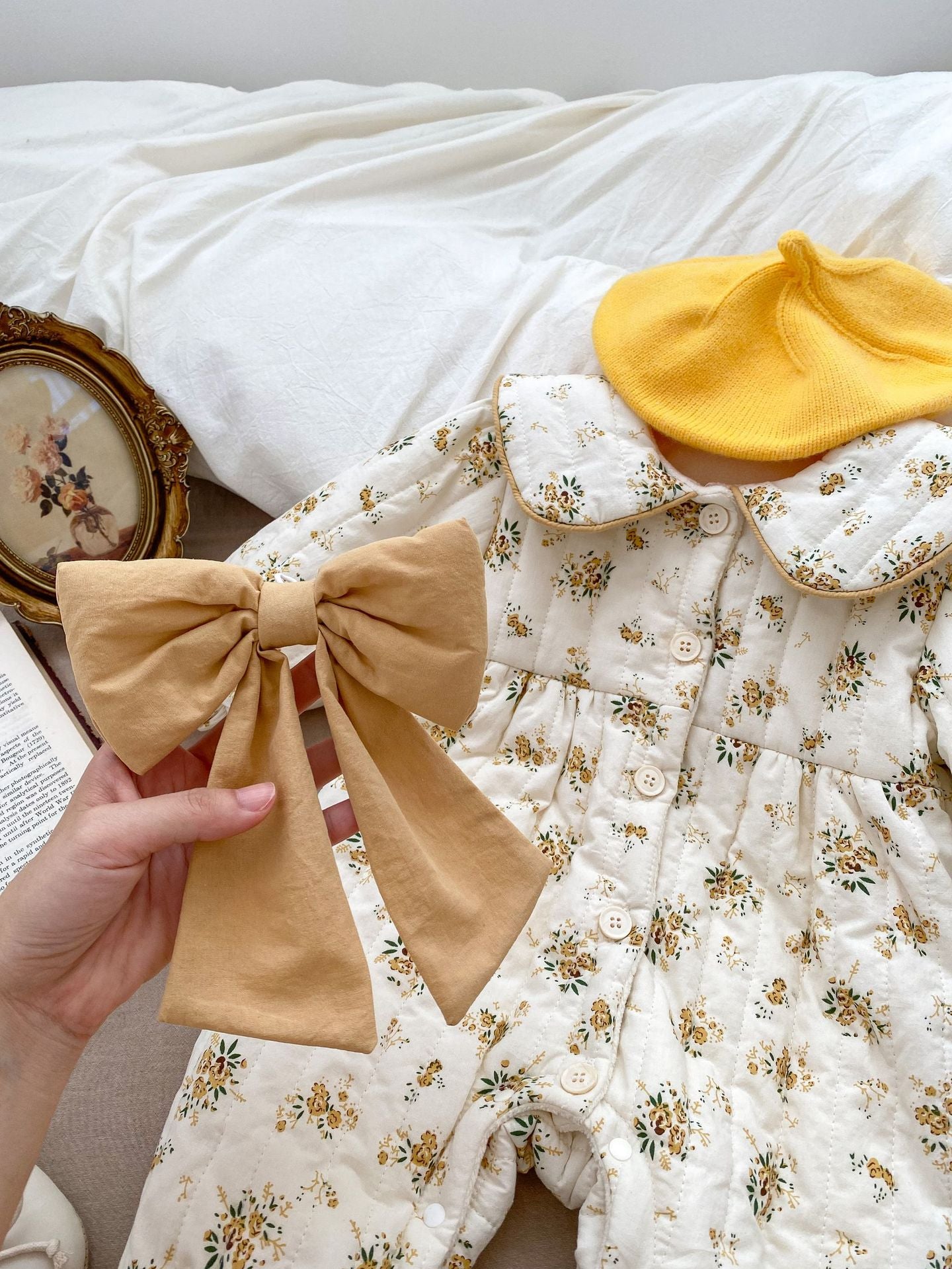 Baby toddler girl wearing a beige fleece floral print outfit with a big bow-knot and long sleeves, perfect for winter.