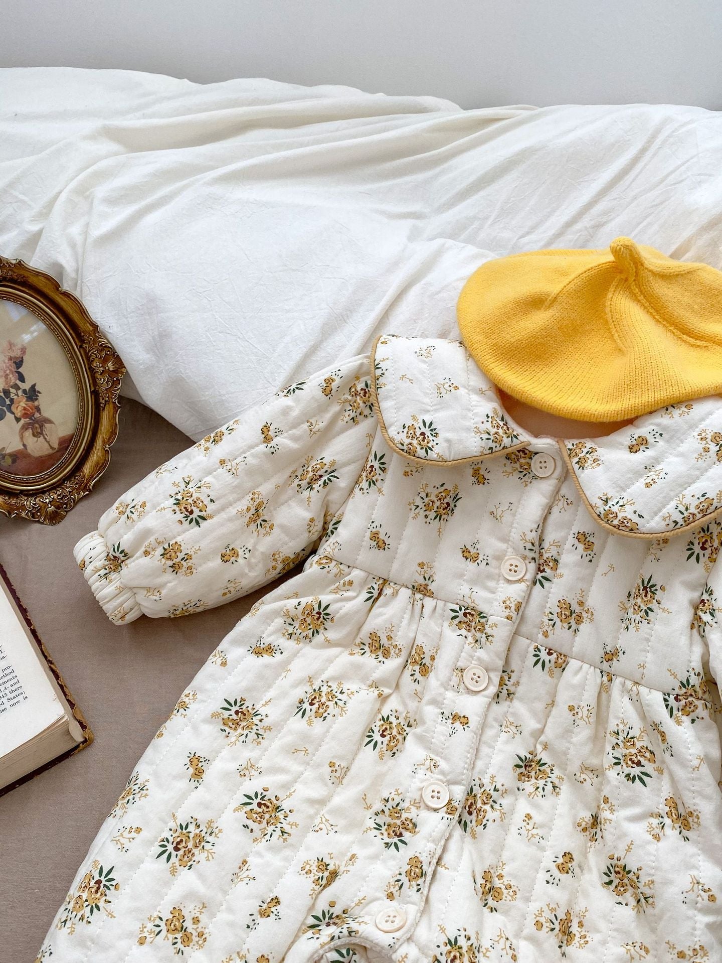 Baby toddler girl wearing a beige fleece floral print outfit with a big bow-knot and long sleeves, perfect for winter.