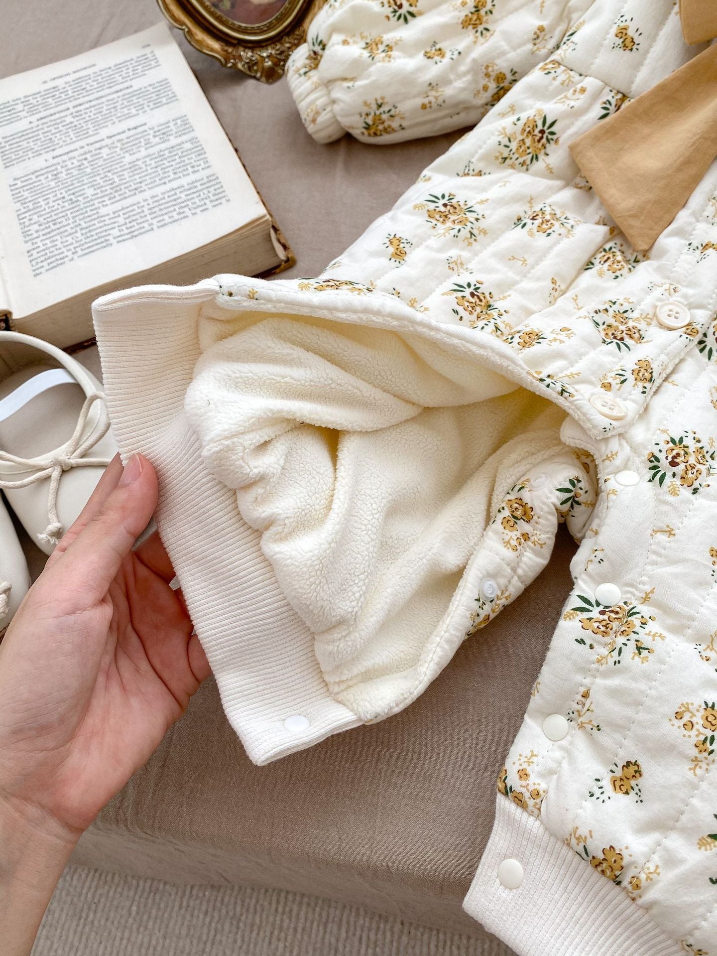 Baby toddler girl wearing a beige fleece floral print outfit with a big bow-knot and long sleeves, perfect for winter.