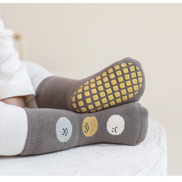 A pair of baby unisex breathable thermal socks featuring cartoon patchwork design in various colors, ideal for toddlers.