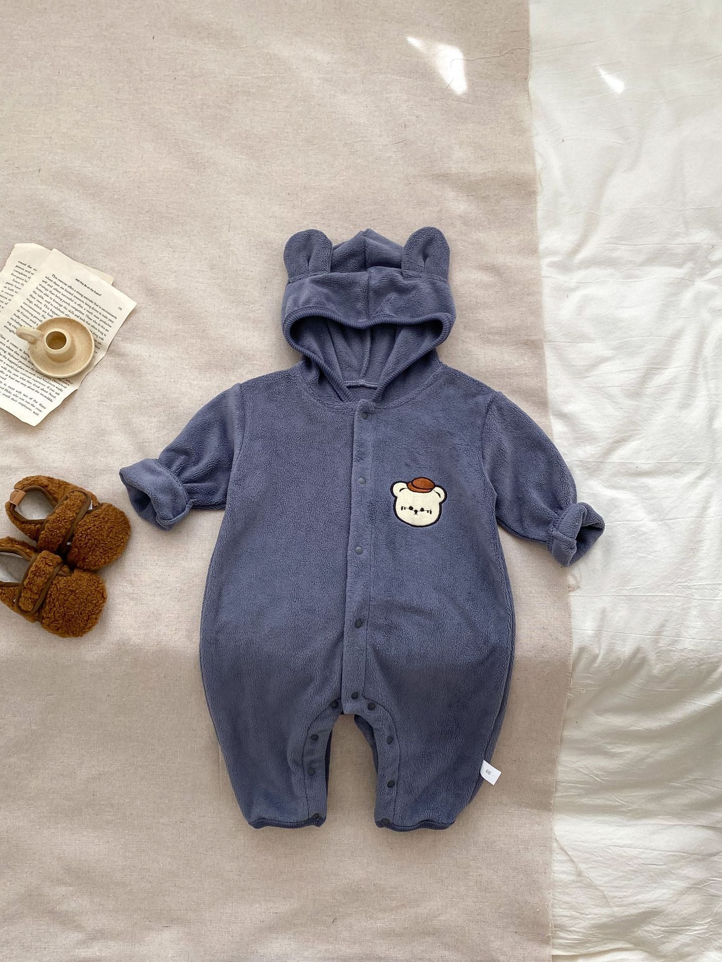 Baby unisex long sleeve romper featuring a cute bear head design, accompanied by a matching hat, available in navy blue, apricot, and brown.