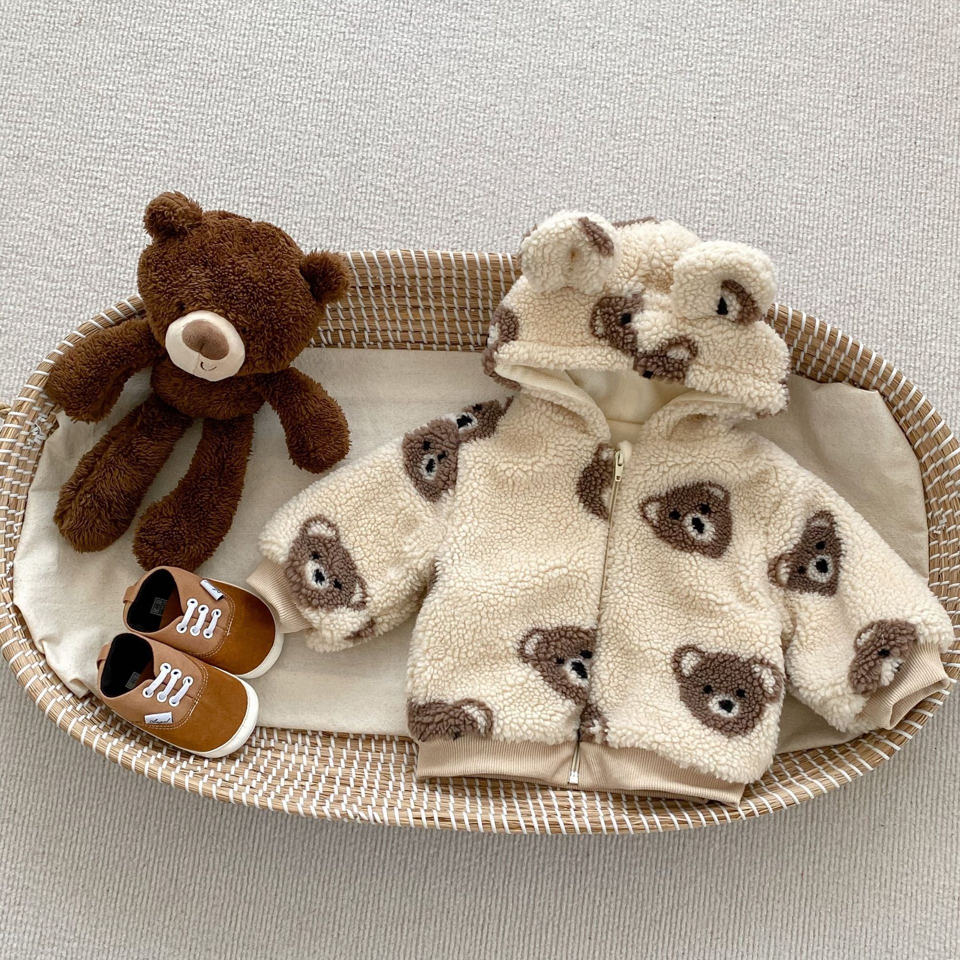 Baby wearing a warm plush coat with a bear head design, perfect for winter.