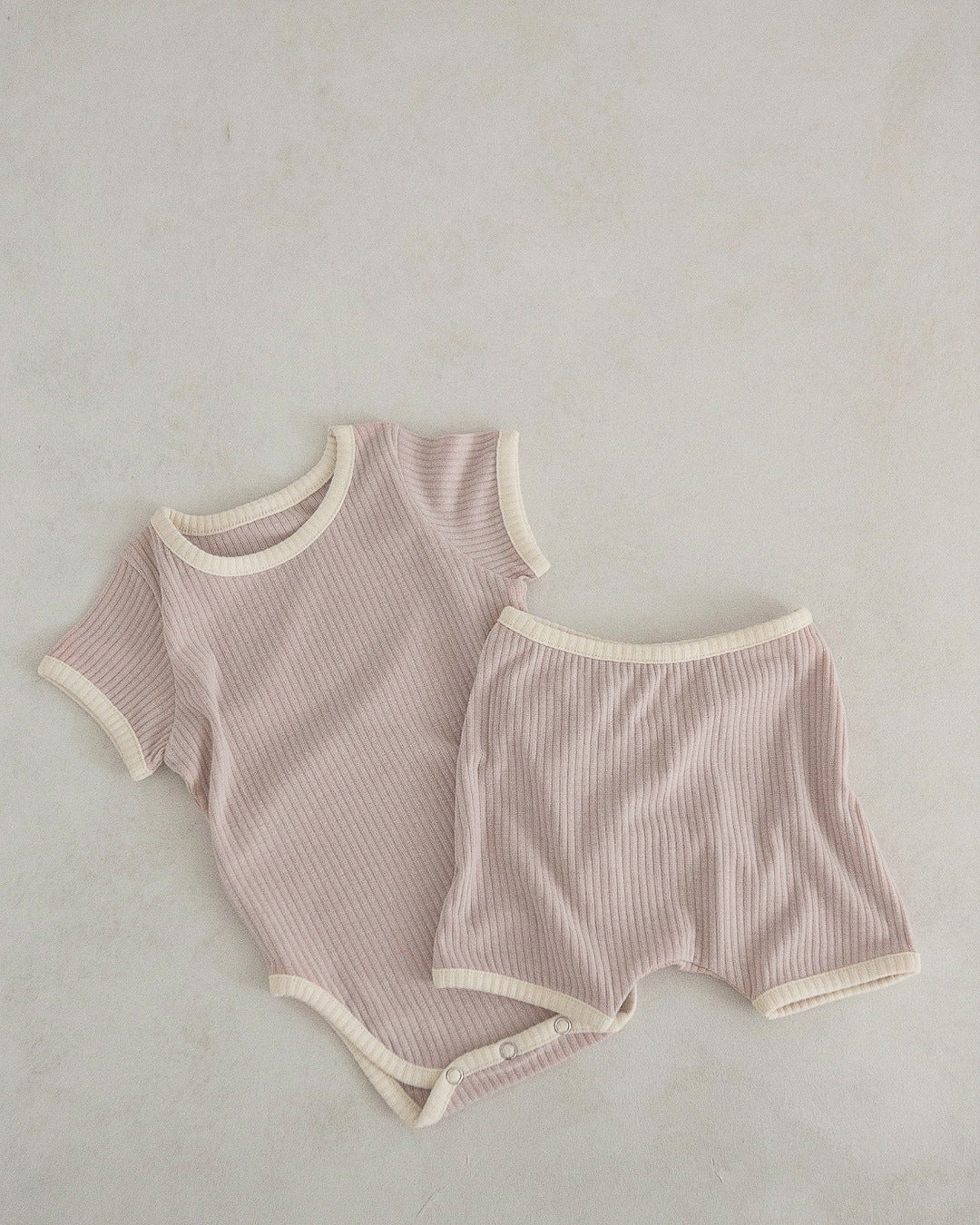 Baby unisex solid color comfy cotton onesies and shorts sets in white, pink, yellow, and apricot, perfect for summer wear.