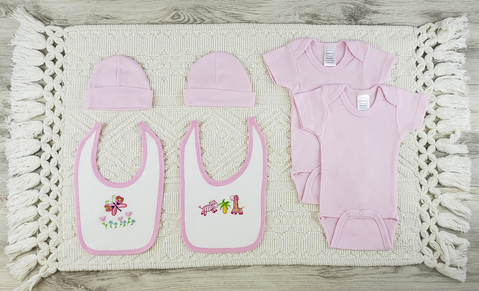 Bambini 6 Pc Layette Baby Clothes Set featuring pink onesies, white bibs, and pink caps made from soft cotton for newborns.