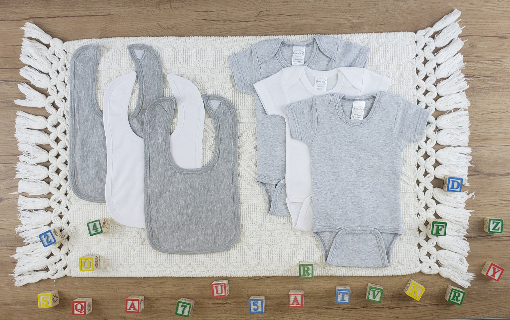 Bambini 6 Pc Layette Baby Clothes Set featuring soft cotton onesies and bibs in grey and white, perfect for newborns.