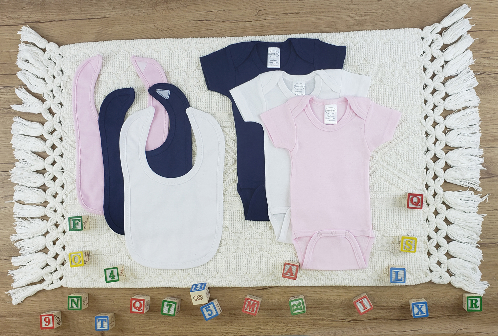 Bambini 6 Pc Layette Baby Clothes Set featuring soft cotton onesies and bibs in pink and navy colors, perfect for newborns.