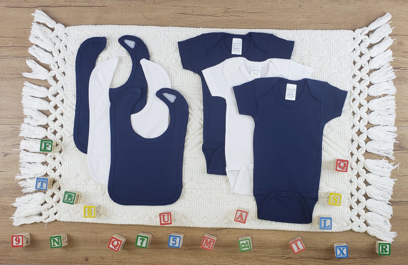 Bambini 6 Pc Layette Baby Clothes Set featuring soft cotton onesies and bibs in navy and white, perfect for newborns.