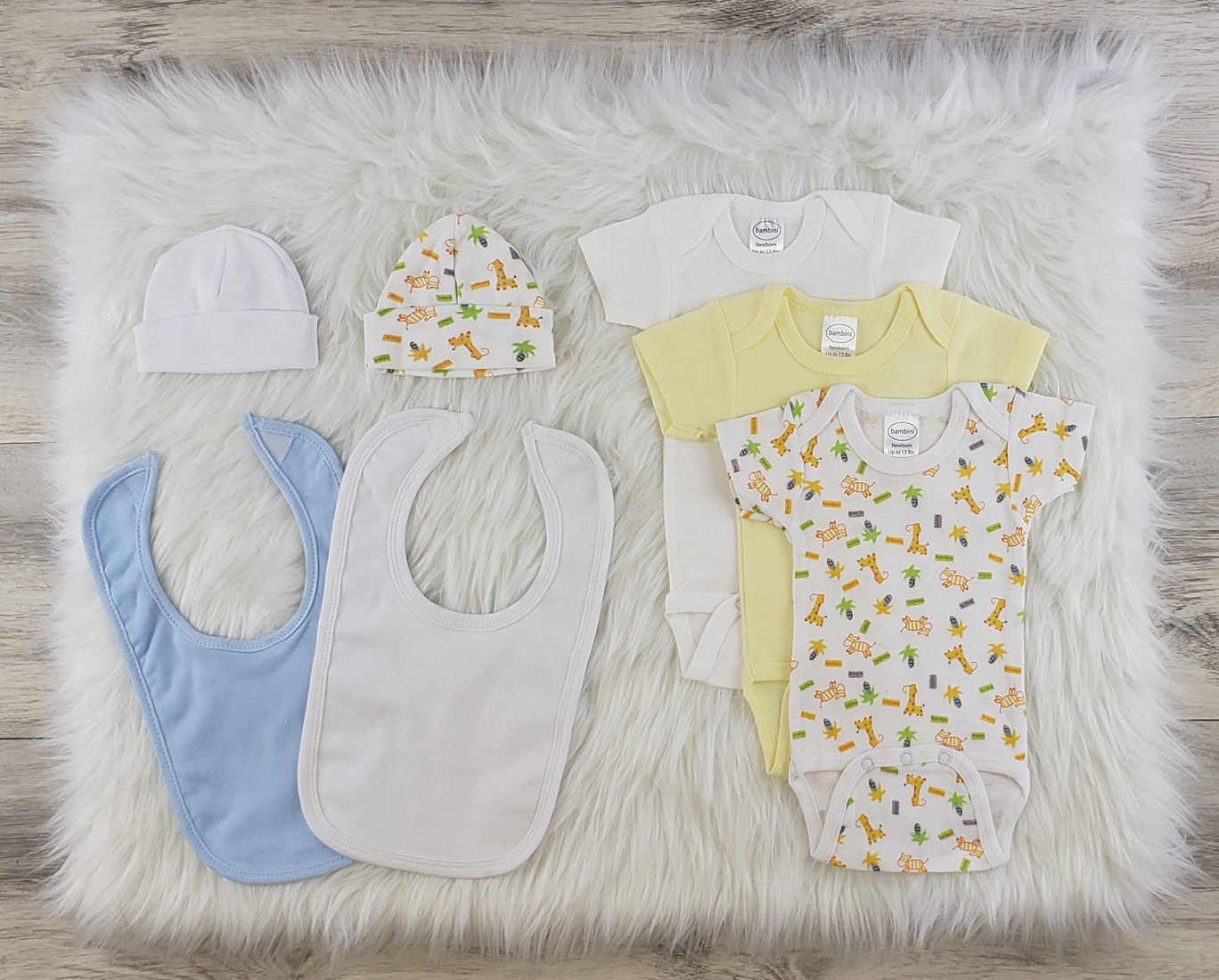 Bambini 7 Pc Layette Baby Clothes Set featuring soft cotton onesies, caps, and bibs in a stylish arrangement.