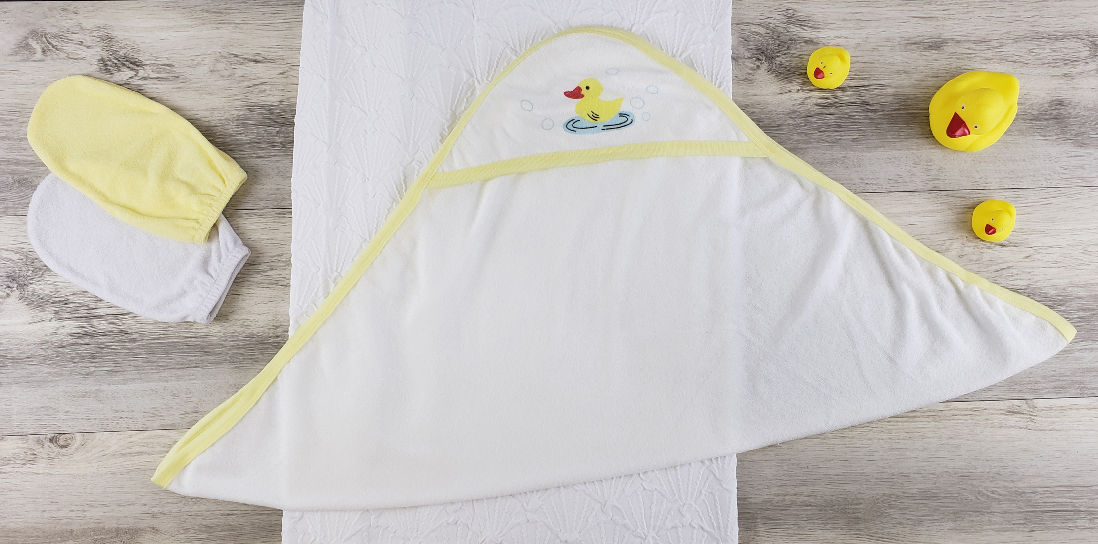 Bambini Hooded Towel and Bath Mittens set featuring soft cotton fabric, expandable neckline, and ribbed leg openings, perfect for newborns.