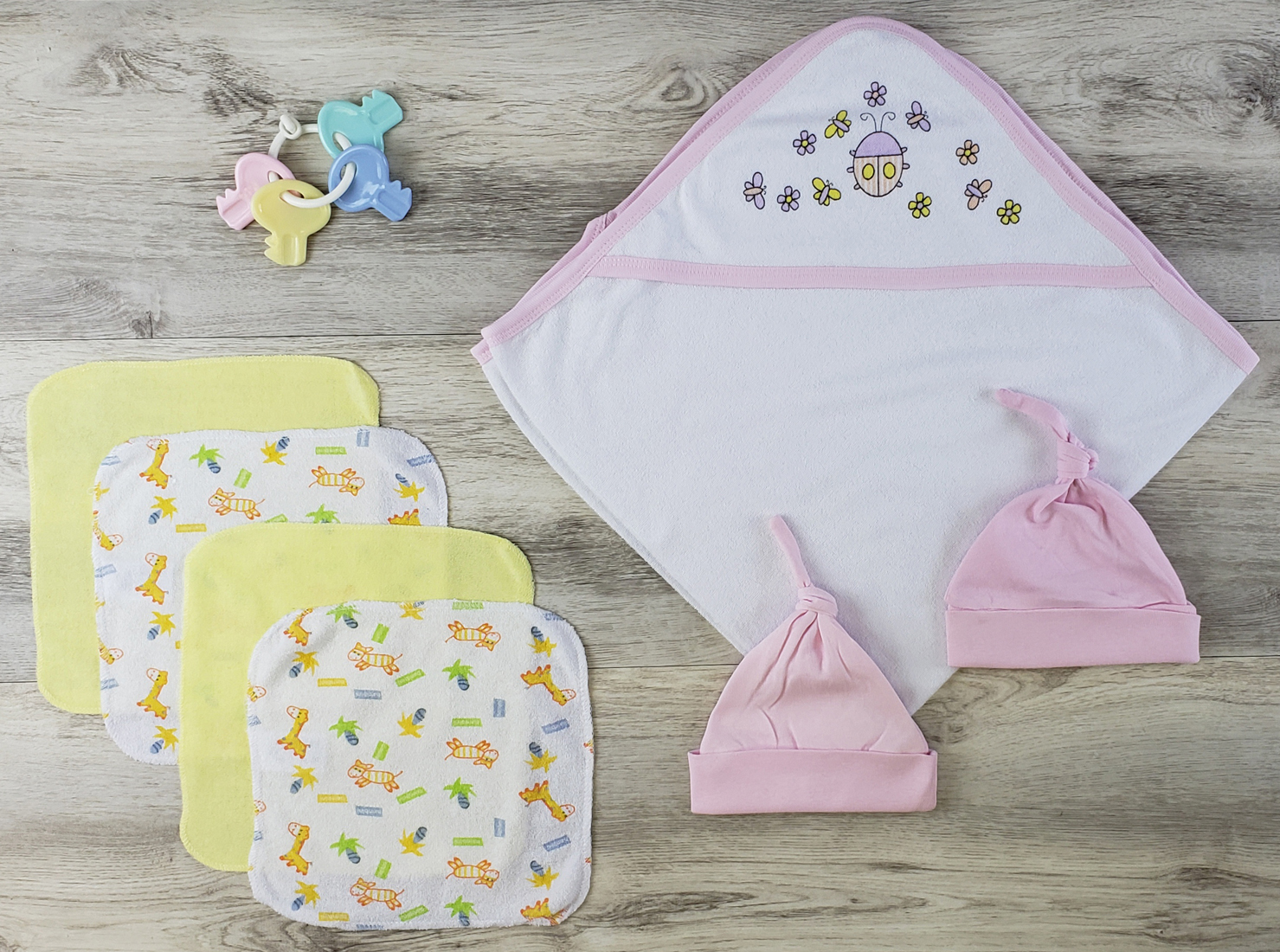 Bambini Hooded Towel set featuring soft cotton towel, pink knotted baby cap, and wash cloths, ideal for newborns.