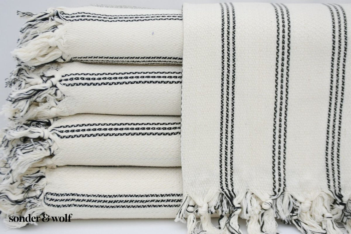 Black and white striped Turkish beach towel, lightweight and stylish, perfect for beach outings and versatile uses.
