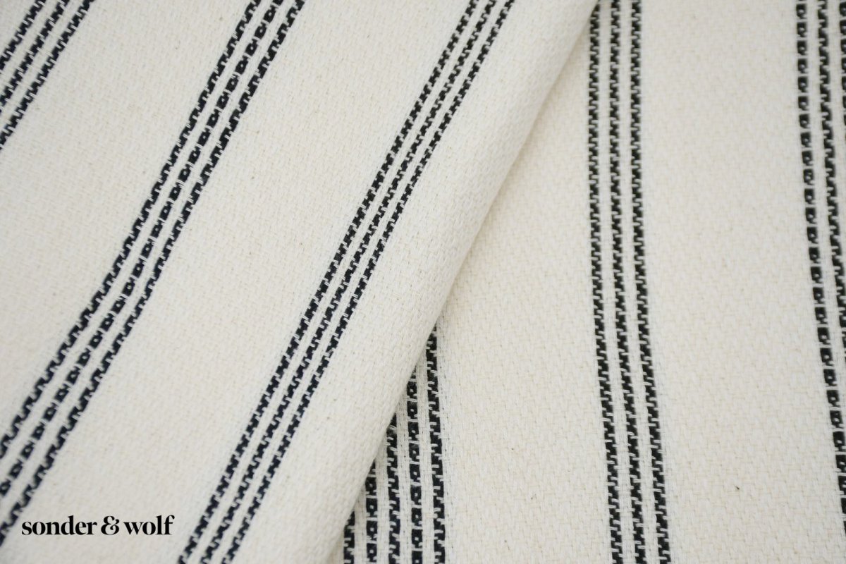 Black and white striped Turkish beach towel, lightweight and stylish, perfect for beach outings and versatile uses.