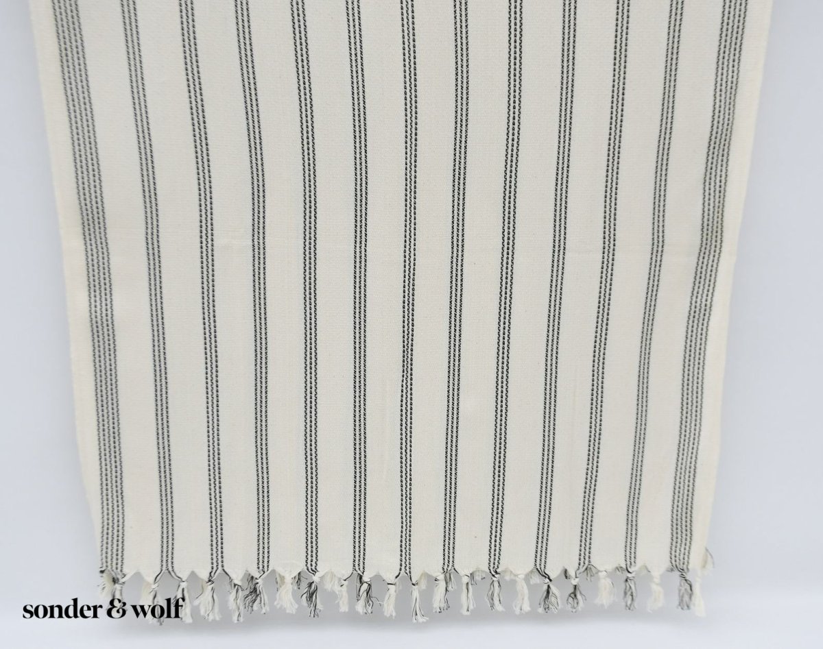 Black and white striped Turkish beach towel, lightweight and stylish, perfect for beach outings and versatile uses.