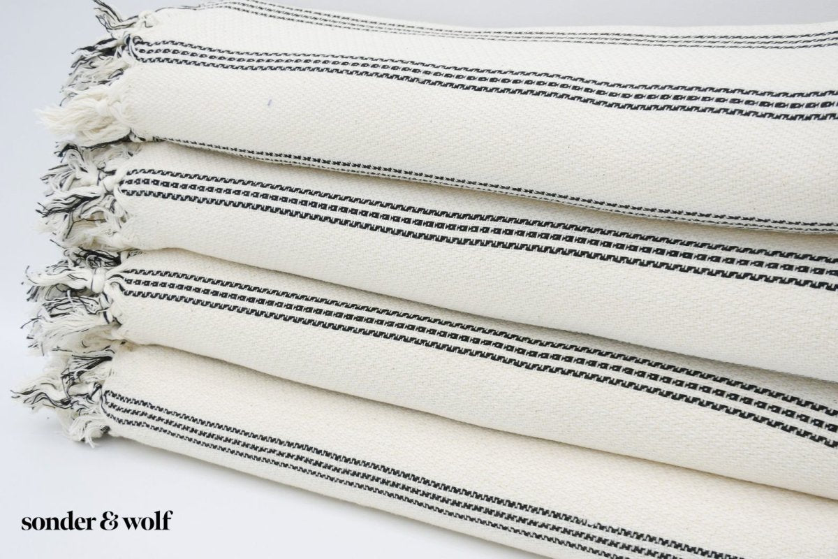 Black and white striped Turkish beach towel, lightweight and stylish, perfect for beach outings and versatile uses.