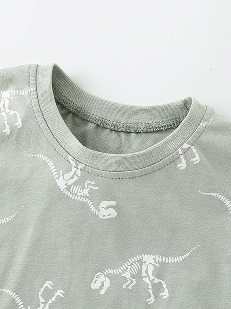 Boys' green short sleeves t-shirt featuring a playful bony dinosaur cartoon pattern, perfect for summer wear.