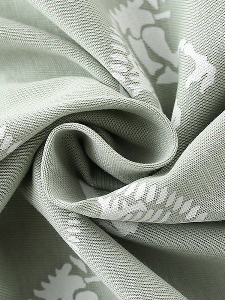 Boys' green short sleeves t-shirt featuring a playful bony dinosaur cartoon pattern, perfect for summer wear.