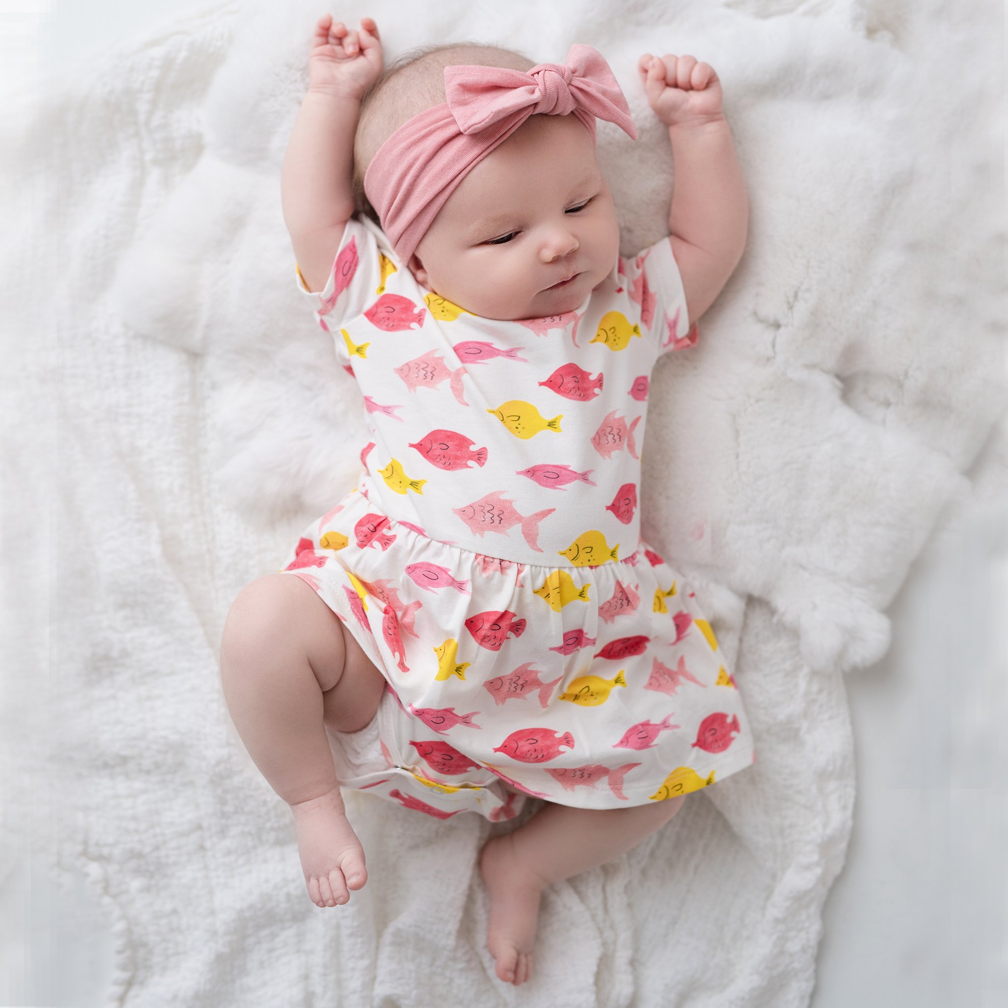 Charlie onesie dress featuring a playful fish print, made from soft cotton with short sleeves and snap bottom for easy changes.