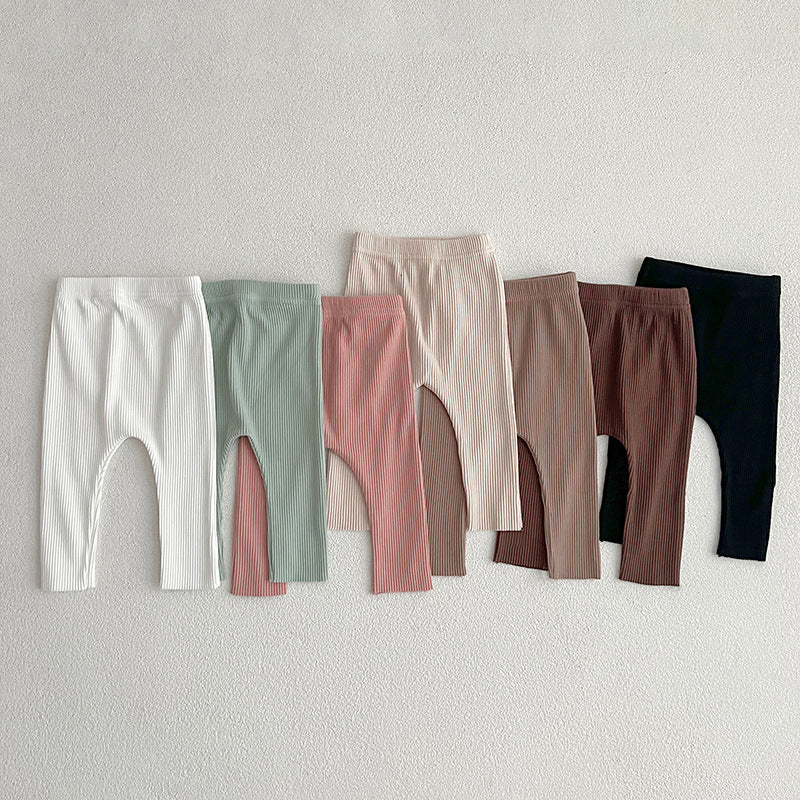 Children's autumn unisex solid color knitted breathable pants in white and apricot, showcasing soft cotton fabric and stylish design.