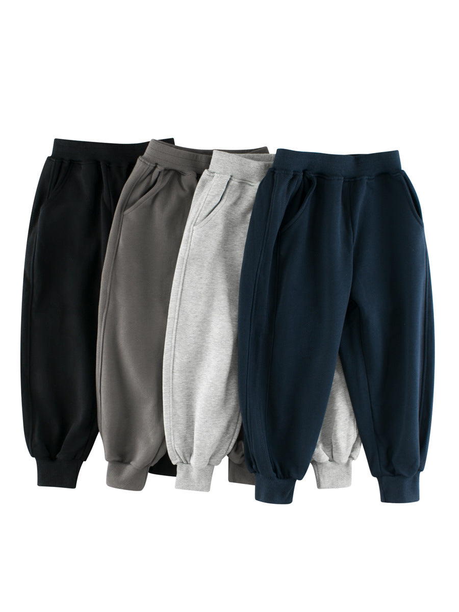 Children's solid color sportswear pants in black, navy blue, grey, and khaki, suitable for boys and girls.