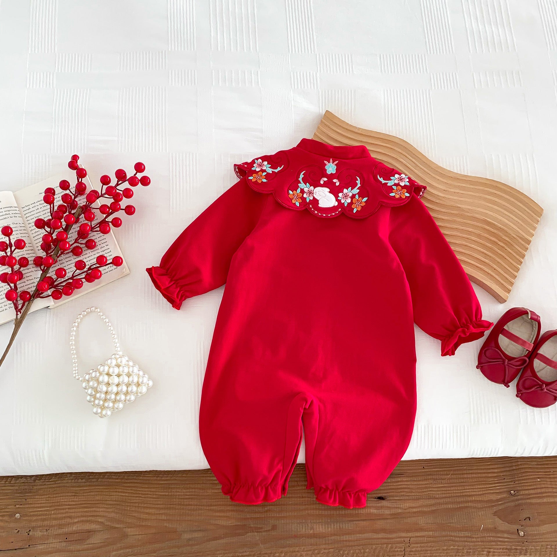 A vibrant red Chinese style romper for baby girls, featuring a floral pattern, perfect for autumn festivals.