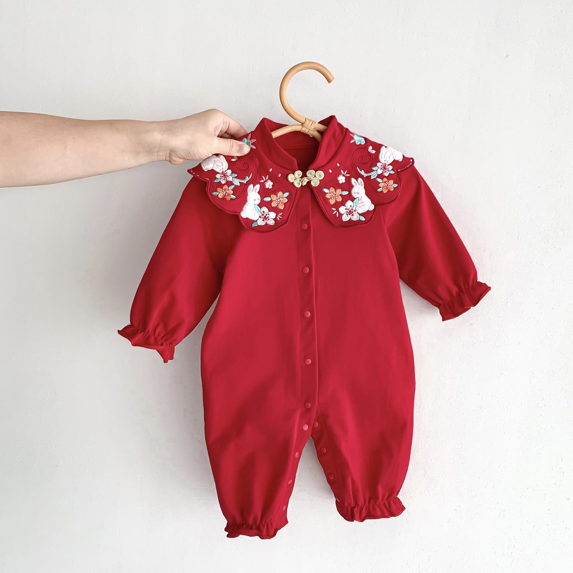 A vibrant red Chinese style romper for baby girls, featuring a floral pattern, perfect for autumn festivals.