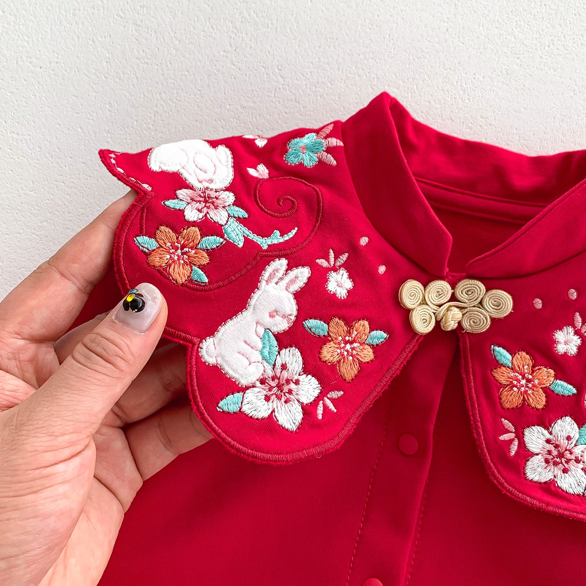 A vibrant red Chinese style romper for baby girls, featuring a floral pattern, perfect for autumn festivals.