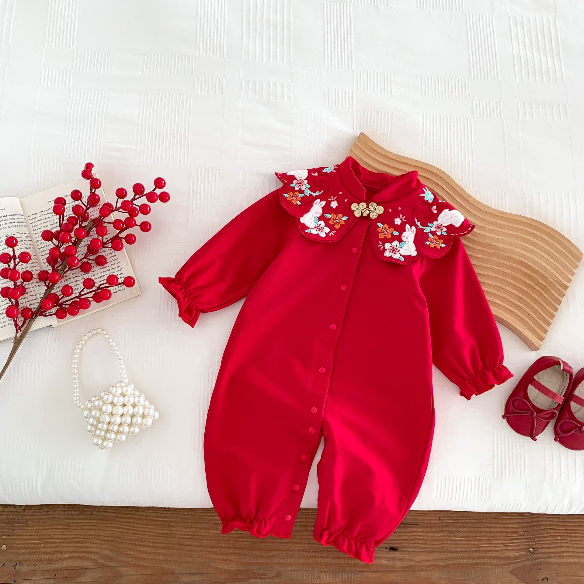 A vibrant red Chinese style romper for baby girls, featuring a floral pattern, perfect for autumn festivals.
