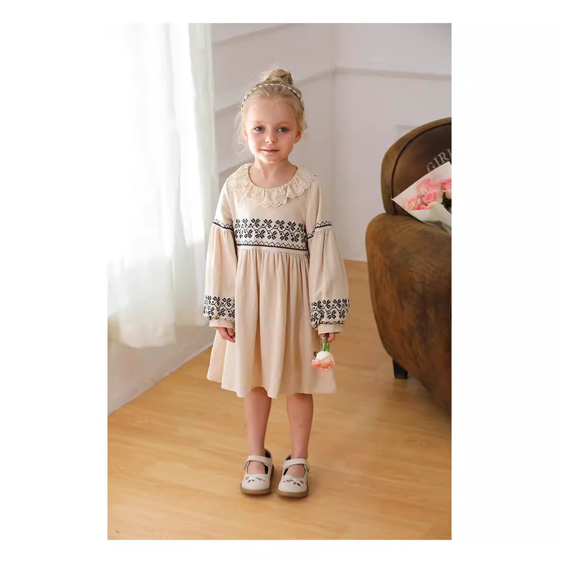 A stylish long dress for girls featuring floral and geometric patterns with a ruffle collar in apricot color.