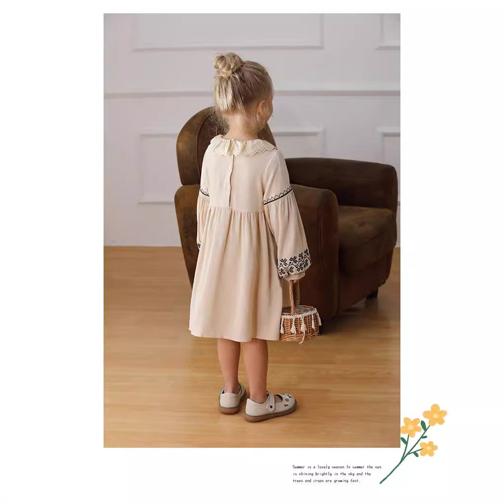 A stylish long dress for girls featuring floral and geometric patterns with a ruffle collar in apricot color.