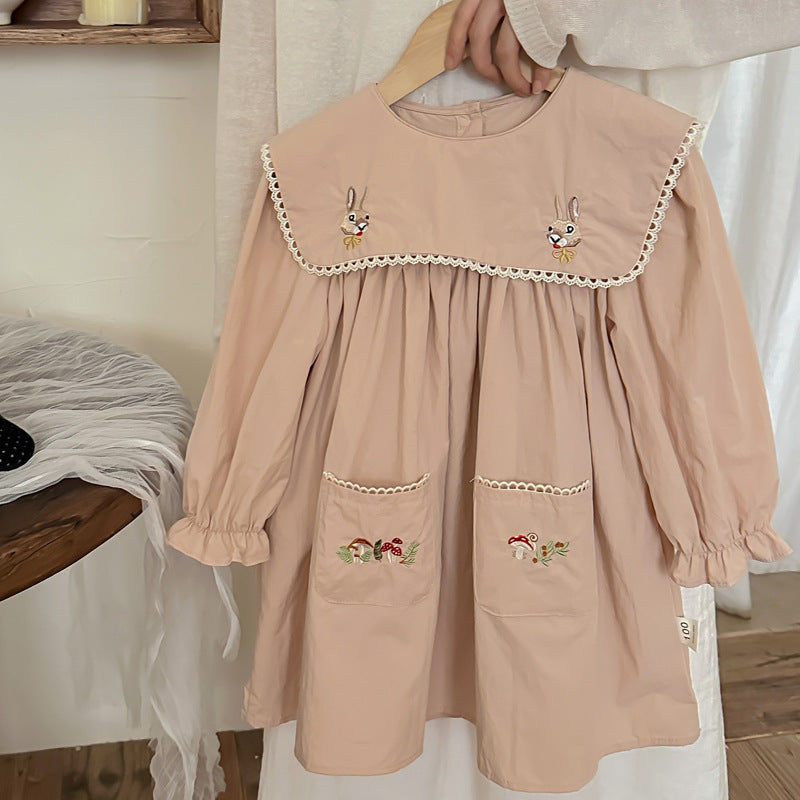 A long dress featuring an embroidered design of rabbits and mushrooms in pink and beige colors, perfect for autumn wear for girls.