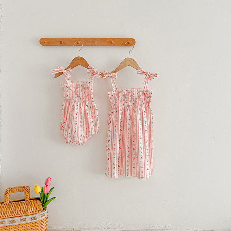 A vibrant summer dress for girls featuring floral and striped patterns, perfect for warm weather, available in pink and green colors.