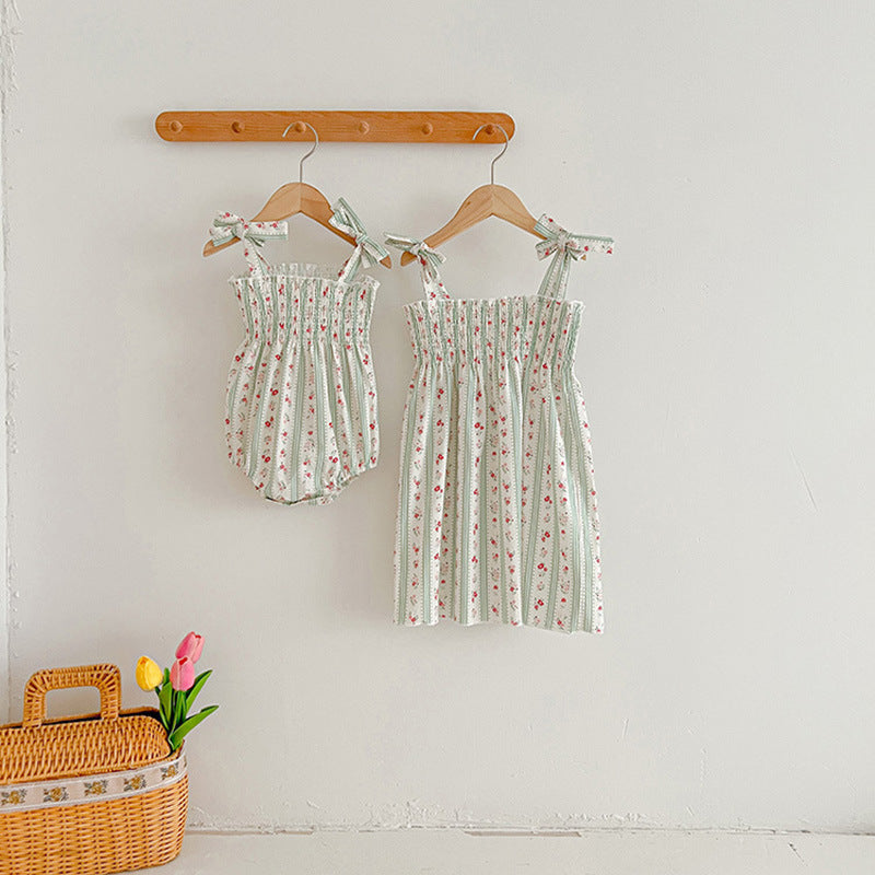 A vibrant summer dress for girls featuring floral and striped patterns, perfect for warm weather, available in pink and green colors.