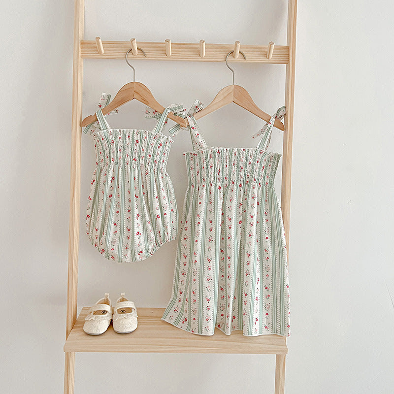 A vibrant summer dress for girls featuring floral and striped patterns, perfect for warm weather, available in pink and green colors.