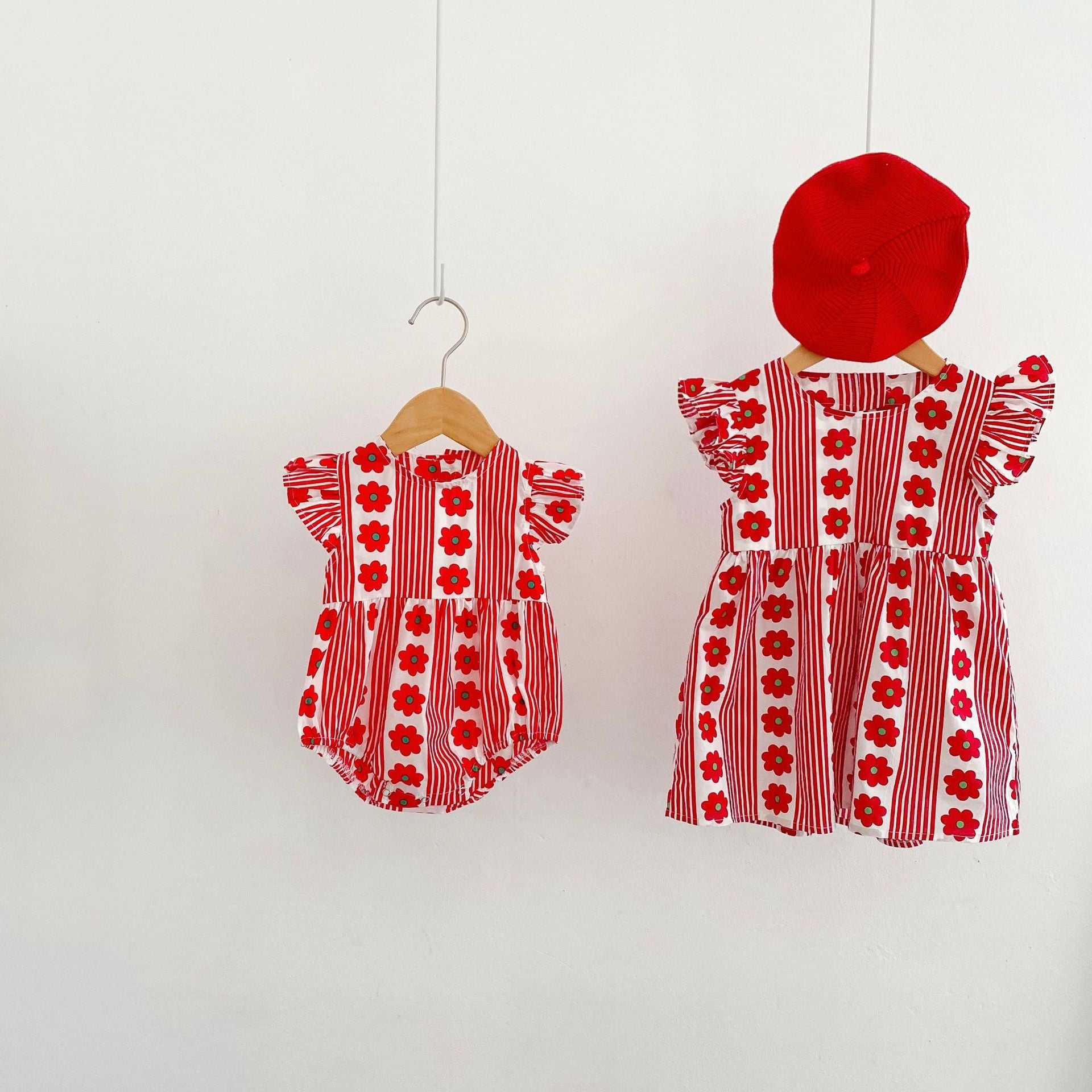 A vibrant summer onesie for girls featuring floral and striped patterns with fly sleeves, available in red and pink colors.