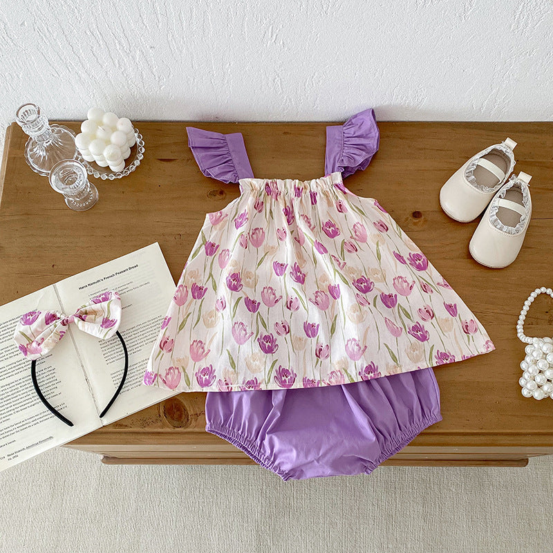 A vibrant summer onesie for girls featuring a floral pattern in purple and apricot colors, designed for comfort and style.