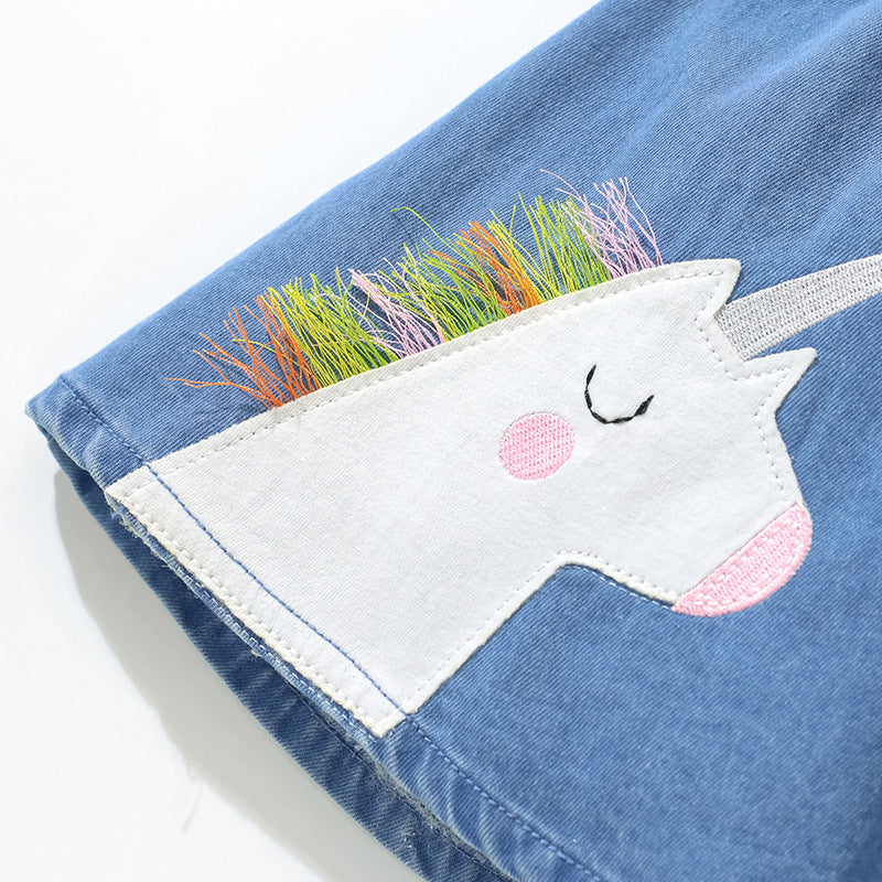 Girls denim skirt featuring unicorn and rainbow cartoon embroidery, perfect for summer wear.