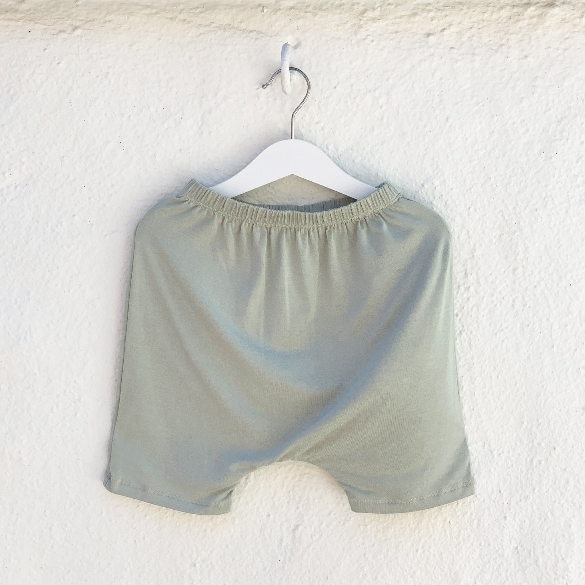 Hammer Shorties in Desert Sage featuring a monster peek-a-boo back pocket and drop crotch harem style, made from super soft fabric.
