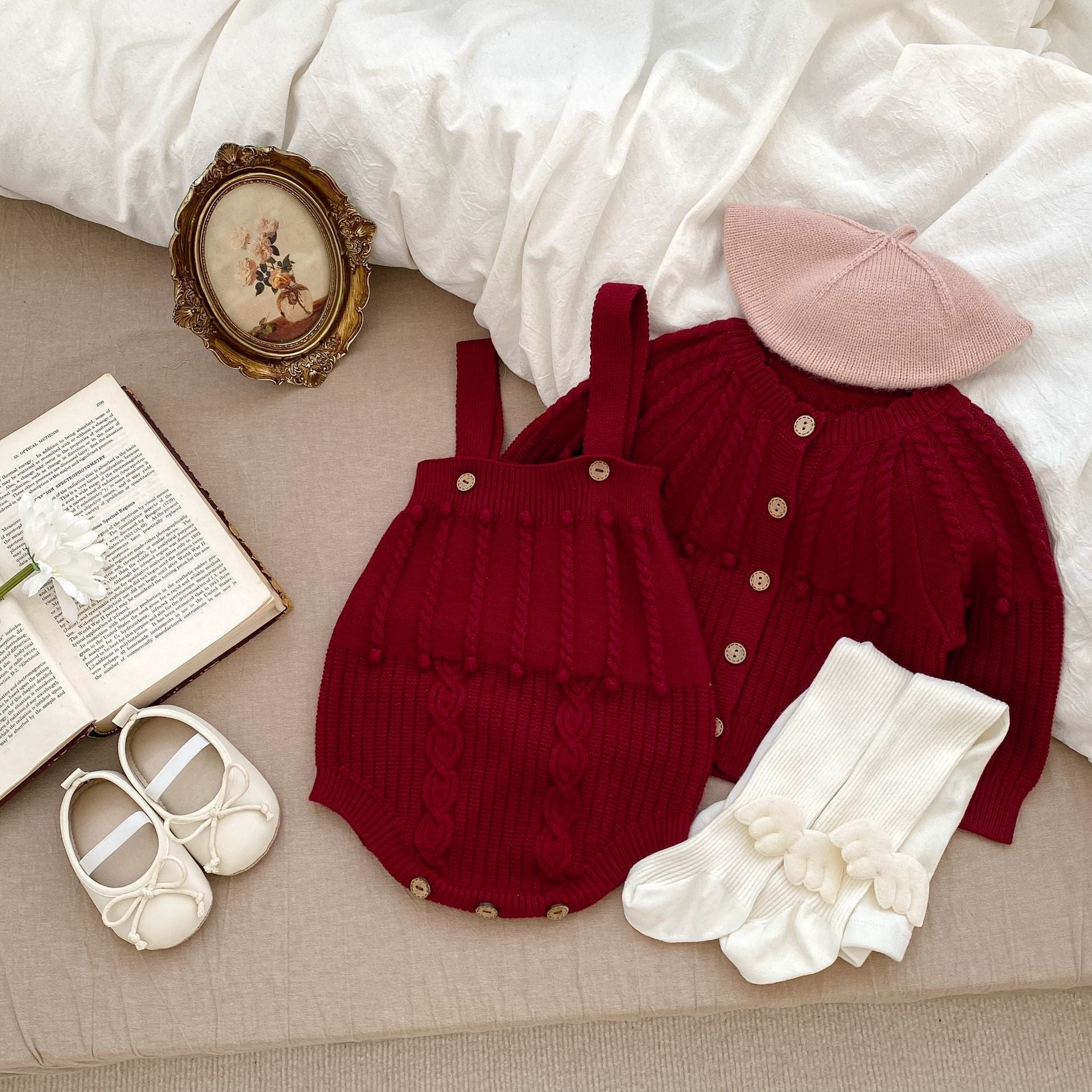 A handmade knitted cardigan set for baby girls, featuring a white and red color scheme, crafted from soft cotton material.