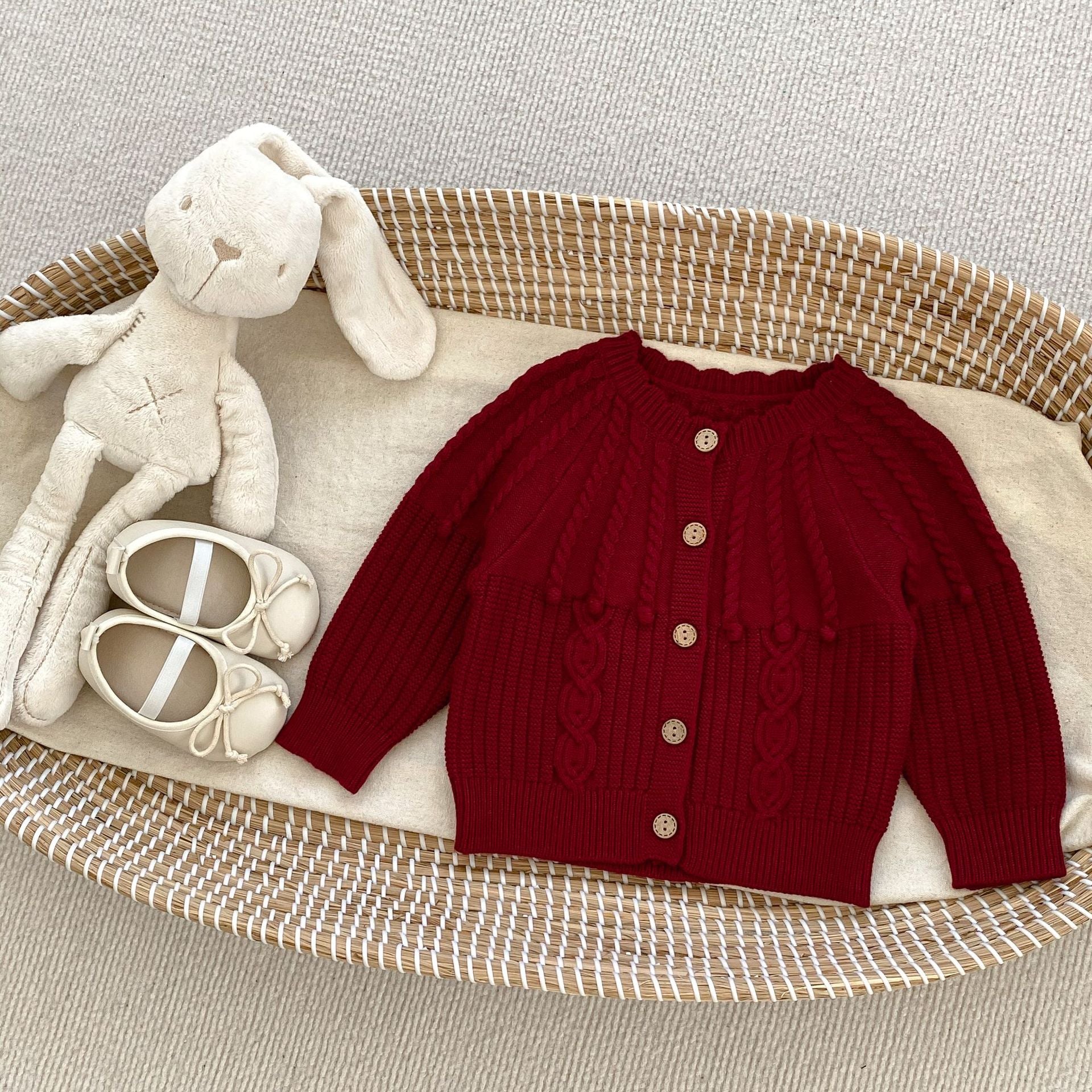 A handmade knitted cardigan set for baby girls, featuring a white and red color scheme, crafted from soft cotton material.