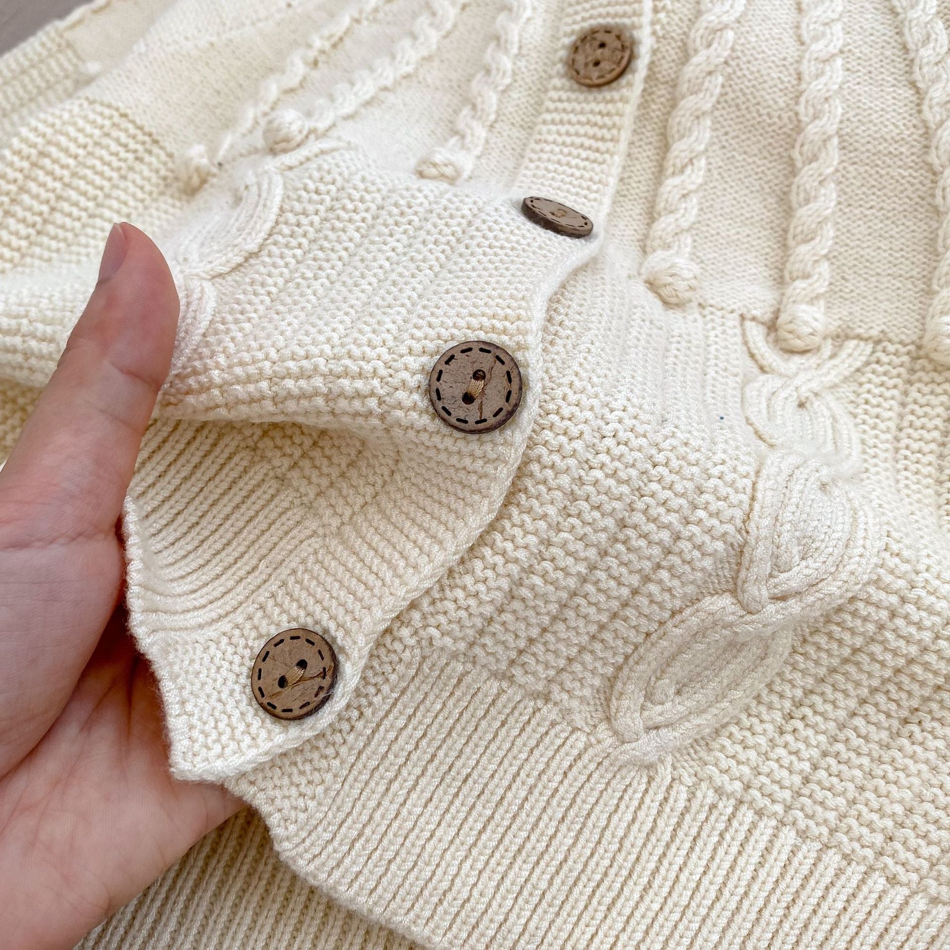 A handmade knitted cardigan set for baby girls, featuring a white and red color scheme, crafted from soft cotton material.