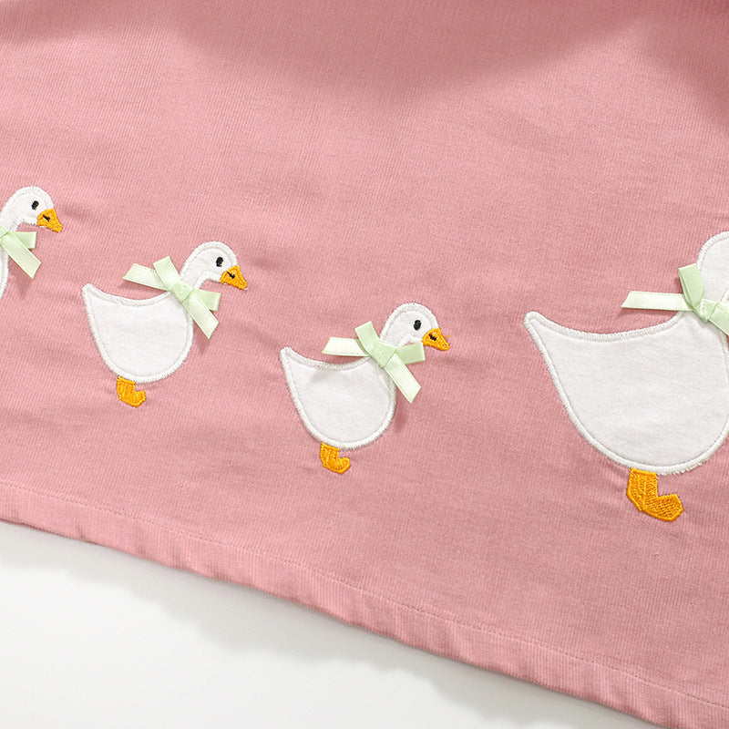 A vibrant sleeveless dress for girls featuring cartoon graphics in pink and blue colors, made from soft cotton fabric.