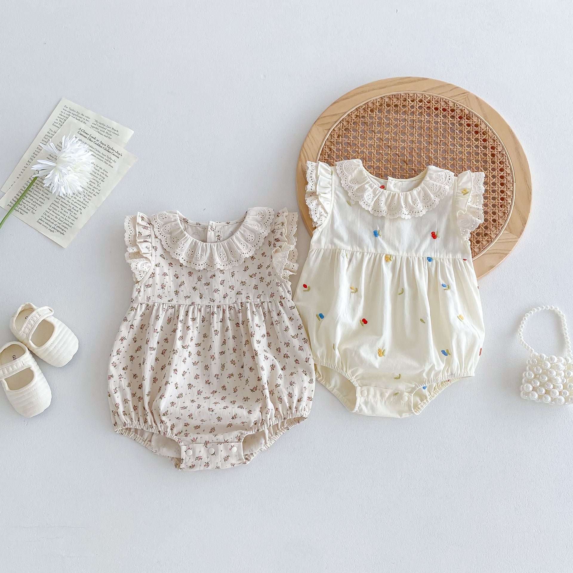 A cute summer dress for baby girls featuring a floral pattern, sleeveless design, and available in white and pink colors.
