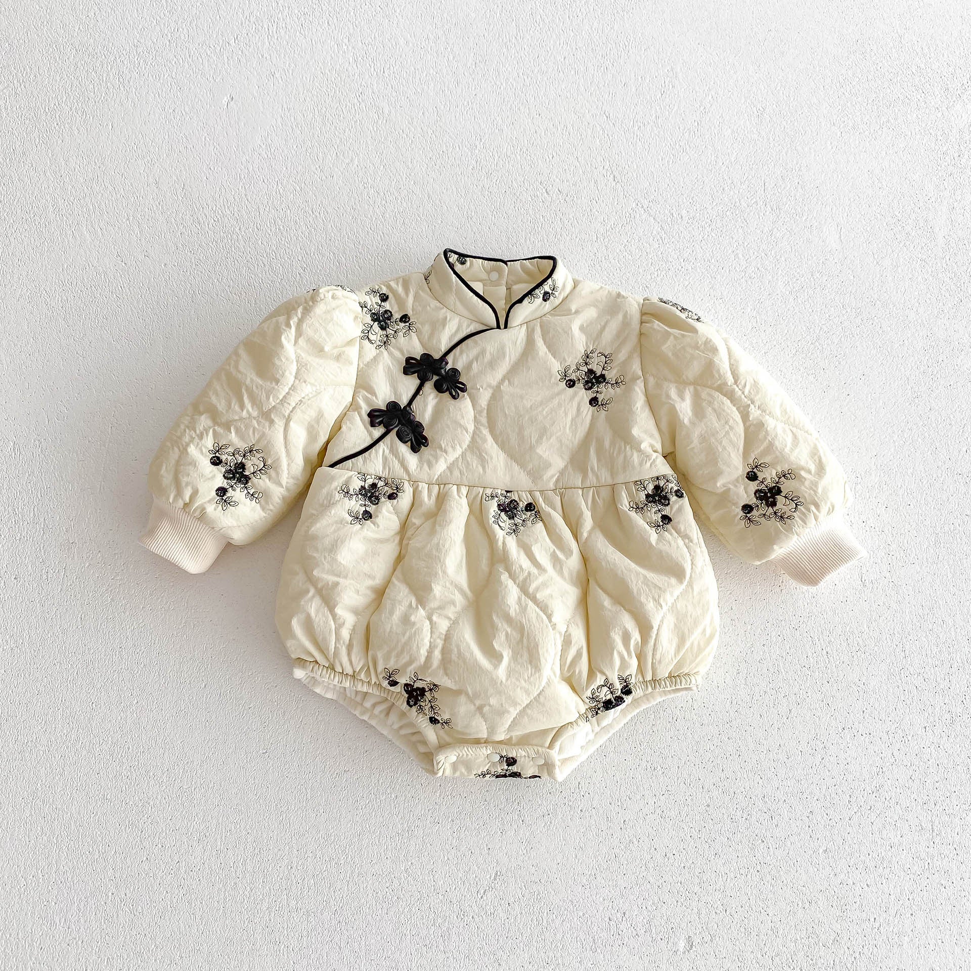 Infant baby girl wearing a thick warm long sleeve one piece in apricot color with jacquard embroidery.