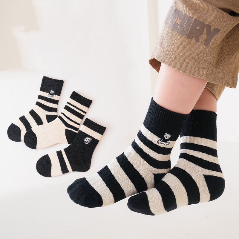 A colorful set of kids unisex crew socks featuring embroidery patterns, available in various colors and fun designs.