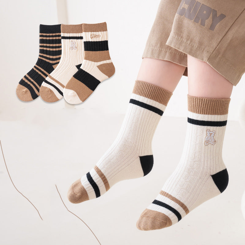 A colorful set of kids unisex crew socks featuring embroidery patterns, available in various colors and fun designs.