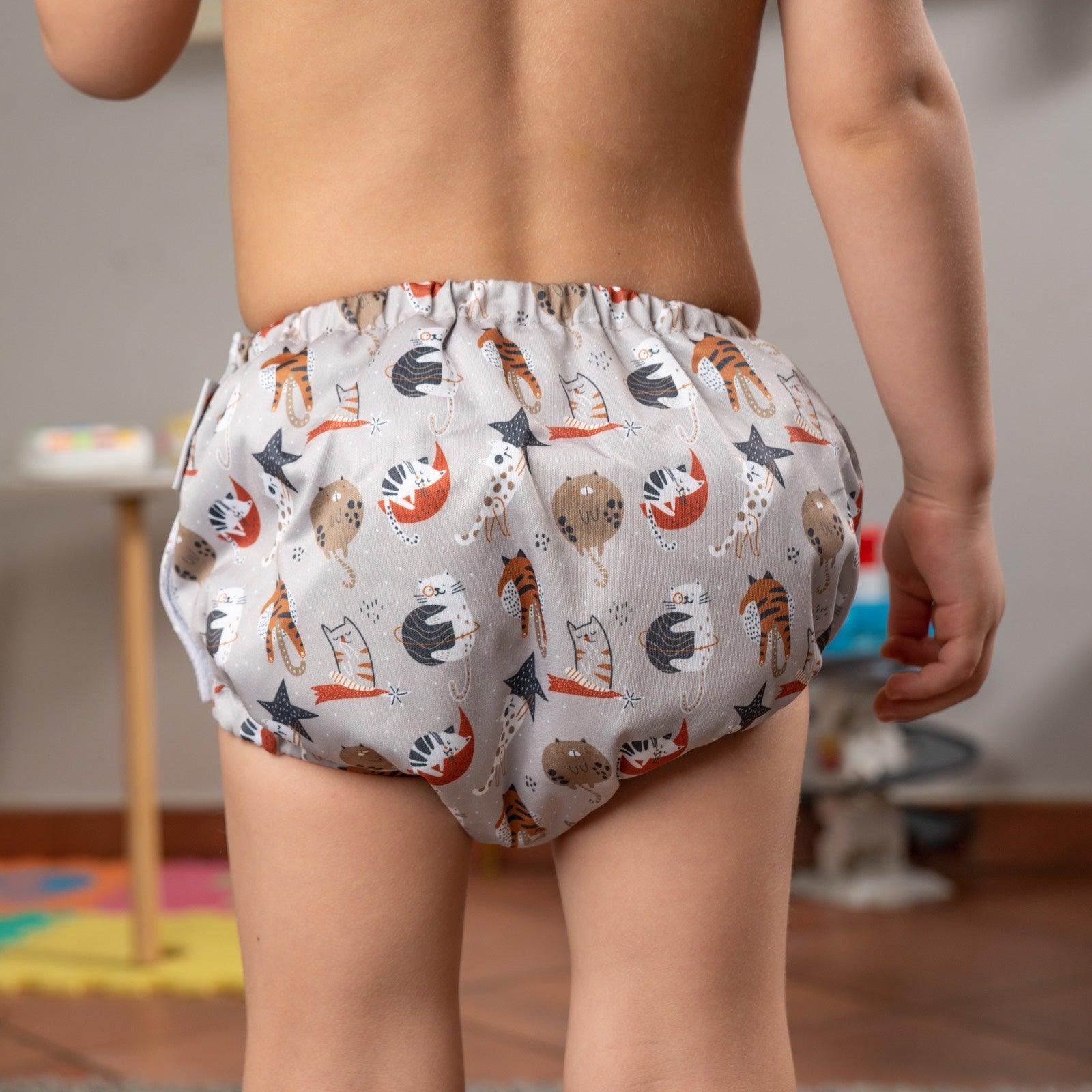 TITTI Pocket-Trainer washable diaper featuring a playful cat design, showcasing its waterproof exterior and adjustable Velcro closure.