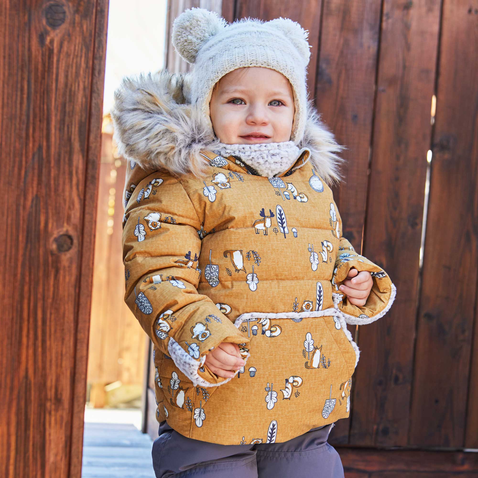A vibrant yellow two-piece baby snowsuit featuring woodland animal prints, with solid pants and a printed jacket, designed for warmth and style.